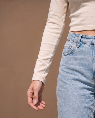 Close-up of beige long-sleeve top showing ruched cuff and cropped hem – Moriel Heritage