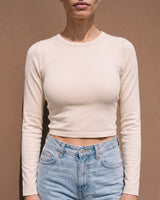 Model wearing beige long-sleeve crew-neck top, close front view – Moriel Heritage