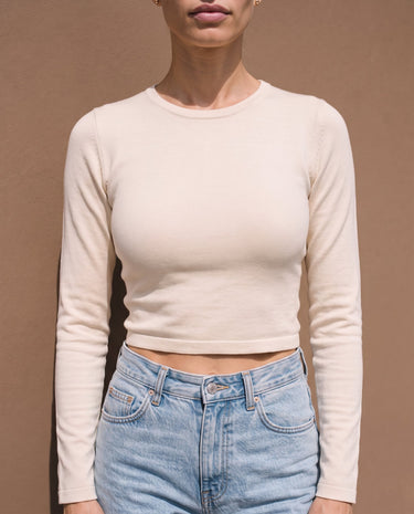 Model wearing beige long-sleeve crew-neck top, close front view – Moriel Heritage