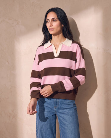 Striped Knit Polo Sweater in pink and cocoa — model adjusting ribbed cuff, three-quarter view