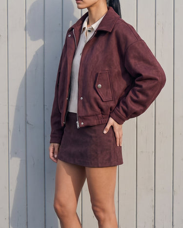 Three-quarter view of the burgundy suede-look bomber jacket showing the dropped shoulder and cuffed sleeves