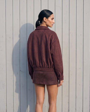 Back view of the burgundy suede-look bomber jacket showing the elasticated hem