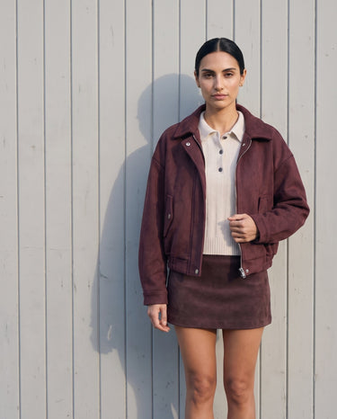 Model wearing the burgundy suede-look bomber jacket zipped low, front view
