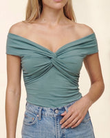 Model wearing the green off-shoulder twist-front top, close front view – Moriel Heritage