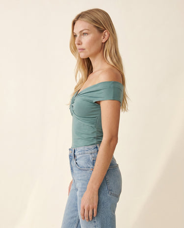 Side profile of the green off-shoulder top showing the fitted body – Moriel Heritage