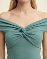 Close-up of the green top's twisted bust detail and off-shoulder neckline – Moriel Heritage