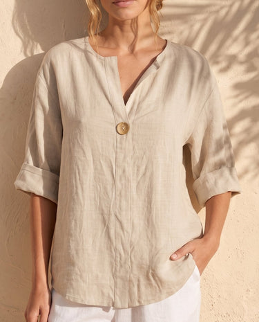 The Aire Relaxed Shirt in beige — relaxed V-neck shirt, front view on model