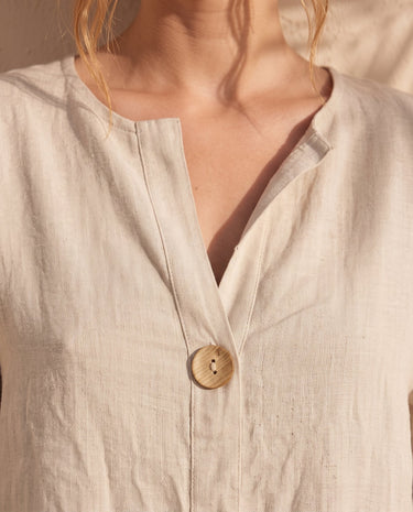 The Aire Relaxed Shirt in beige — close-up of V-neck and wood button detail