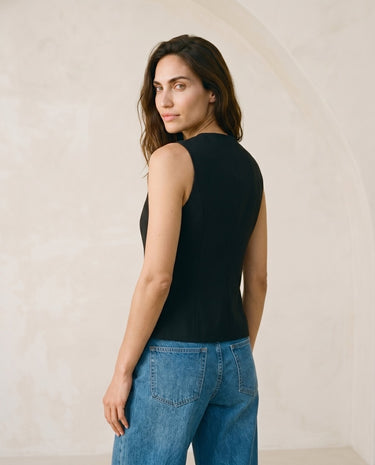 The Alicia vest in black — side profile view on model