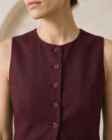 The Alicia vest in burgundy — close-up of the neckline and button front