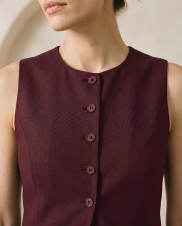 The Alicia vest in burgundy — close-up of the neckline and button front