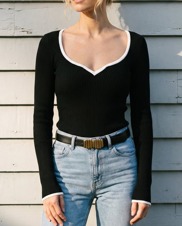 Close front view of the black ribbed knit top worn with light-wash jeans – Moriel Heritage