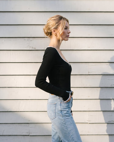 Side view of the black ribbed knit top showing the fitted body and long sleeves – Moriel Heritage