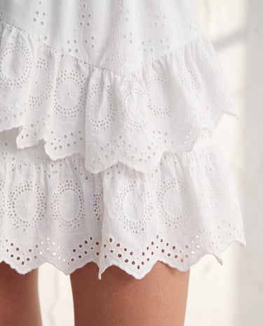 The Amour Lace Mini Skirt in white — close-up of tiered eyelet-lace ruffles