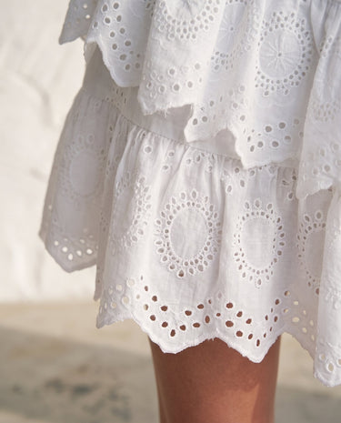The Amour Lace Mini Skirt in white — close-up of scalloped eyelet-lace hem