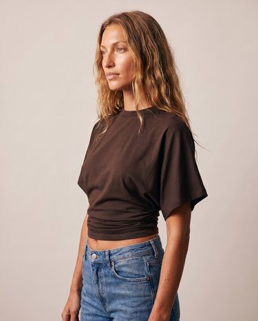 Side view of the brown ruched-side tee worn with blue jeans – Moriel Heritage