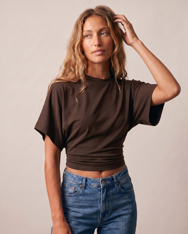 Model with hand in hair wearing the brown ruched-side tee – Moriel Heritage