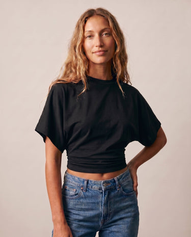 Model wearing the black ruched-side tee with jeans, front view – Moriel Heritage