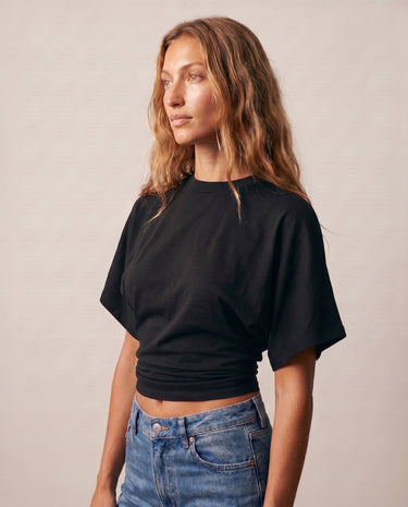 Model in the black ruched-side tee, angled front view – Moriel Heritage
