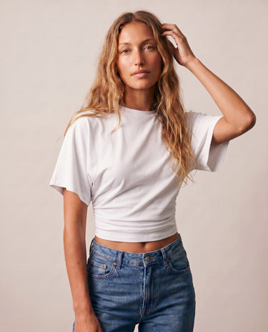 Model with hand in hair wearing the white ruched-side tee – Moriel Heritage