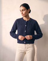 The Arlo Cardigan in navy — front view on model buttoning the cardigan