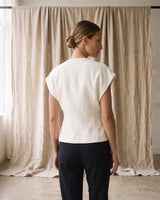 The Asymmetrical Vest in white — sleeveless vest, back view on model