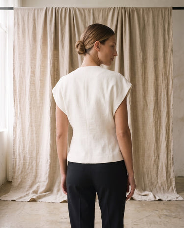 The Asymmetrical Vest in white — sleeveless vest, back view on model