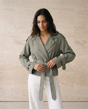 The Avielle Belted Trench in green — belted trench jacket, three-quarter side view on model