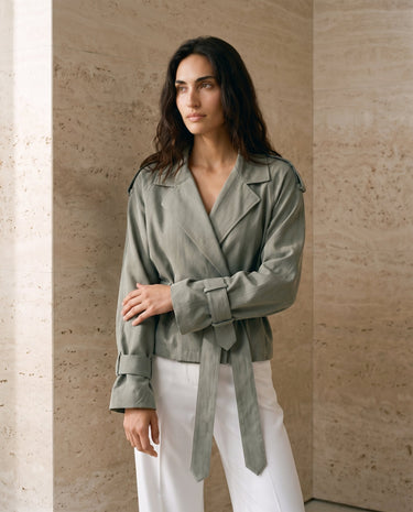 The Avielle Belted Trench in green — belted trench jacket with cuff tabs, side front view on model