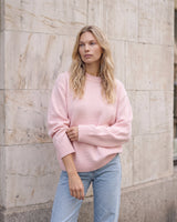 The Blush Sweater in pink — front three-quarter view on model