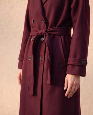 The Burgundy Celine Coat in burgundy — close-up of the tie belt and buttoned cuff