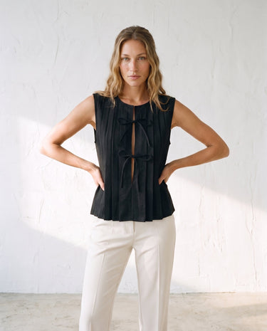 The Cala Cotton Linen Tie Top in black — pleated tie-front top, front styling view on model