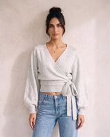 The Calira Wrap Knit in gray — knit wrap top showing side tie, front view on model
