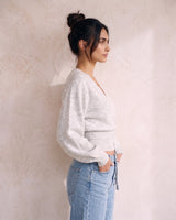 The Calira Wrap Knit in gray — knit wrap top, side view on model