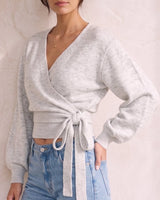 The Calira Wrap Knit in gray — knit wrap top with blouson sleeves, front view on model