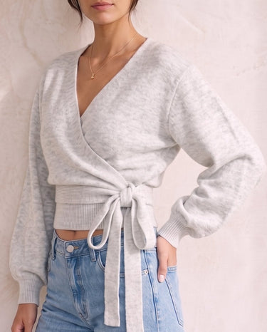 The Calira Wrap Knit in gray — knit wrap top with blouson sleeves, front view on model