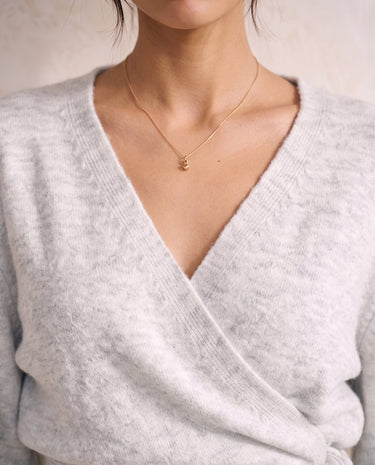 The Calira Wrap Knit in gray — close-up of surplice V neckline and knit texture