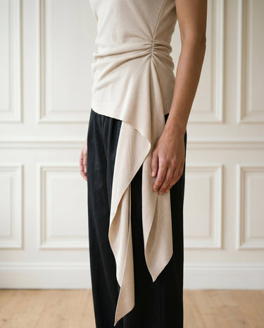 The Camellia Ruffle Top in beige — close-up of gathered waist and cascading ruffle panel detail