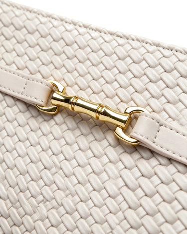Close-up of the Camille Handbag's gold-tone belt clasp and woven leather texture in ivory