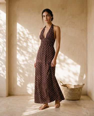 The Capri Polka Dot Dress in brown — polka-dot halter maxi dress, three-quarter view on model