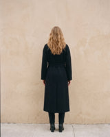 The Caroline Tie Waist Coat in black — longline belted coat, back view on model