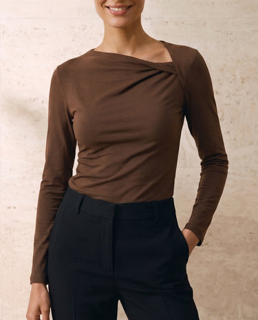 The Celeste Asymmetrical Long Sleeve Top in coffee — asymmetric draped-neck long-sleeve top, front view on model