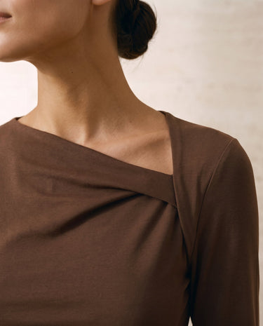 The Celeste Asymmetrical Long Sleeve Top in coffee — close-up of asymmetric draped neckline