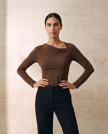 The Celeste Asymmetrical Long Sleeve Top in coffee — asymmetric draped-neck long-sleeve top, front styling view on model