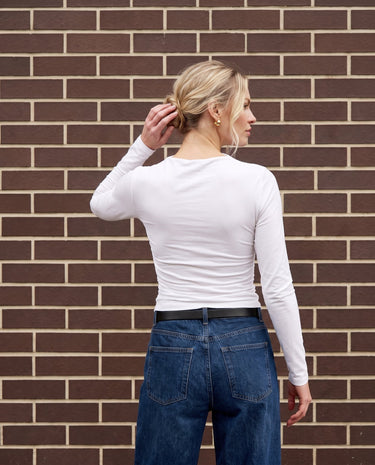 Model wearing white ruched long-sleeve top, back view – Moriel Heritage