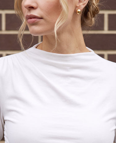 Close-up of white ruched top showing the draped high neckline and shoulder gathering – Moriel Heritage