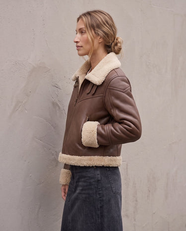 The Cerys Fur Collar Jacket in coffee — faux-leather jacket with faux fur collar, side view on model