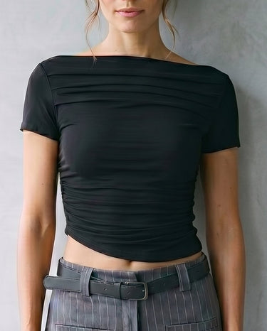 Model wearing black boat-neck top with grey pinstripe trousers, cropped front view – Moriel Heritage