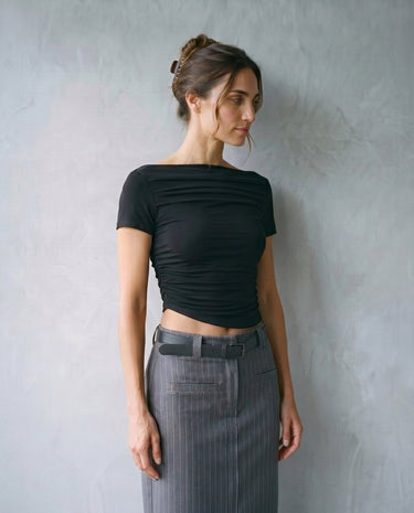 Model wearing black boat-neck top with grey tailored trousers, front view – Moriel Heritage