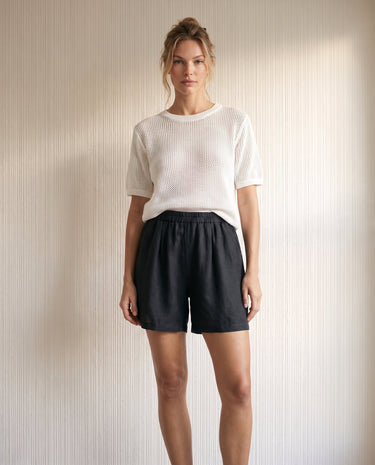 The Ciente Cotton Shorts in black — elastic-waist cotton shorts, full-length front view on model